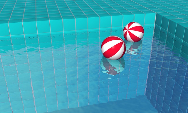 dva červenobílé míče na hladině bazénu